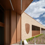 Exterior view of the St. Louis County Precinct 2 front entry showing the copper paneling, brick, and county badge