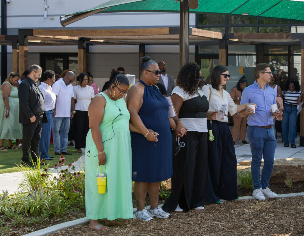 Members of the community join hands at the Urban Sprouts Cafe Au Play Ribbon Cutting
